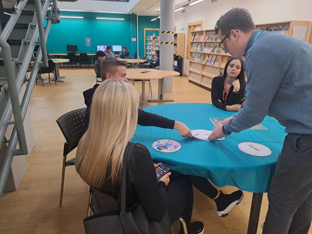 Students sat at a table playing a card game