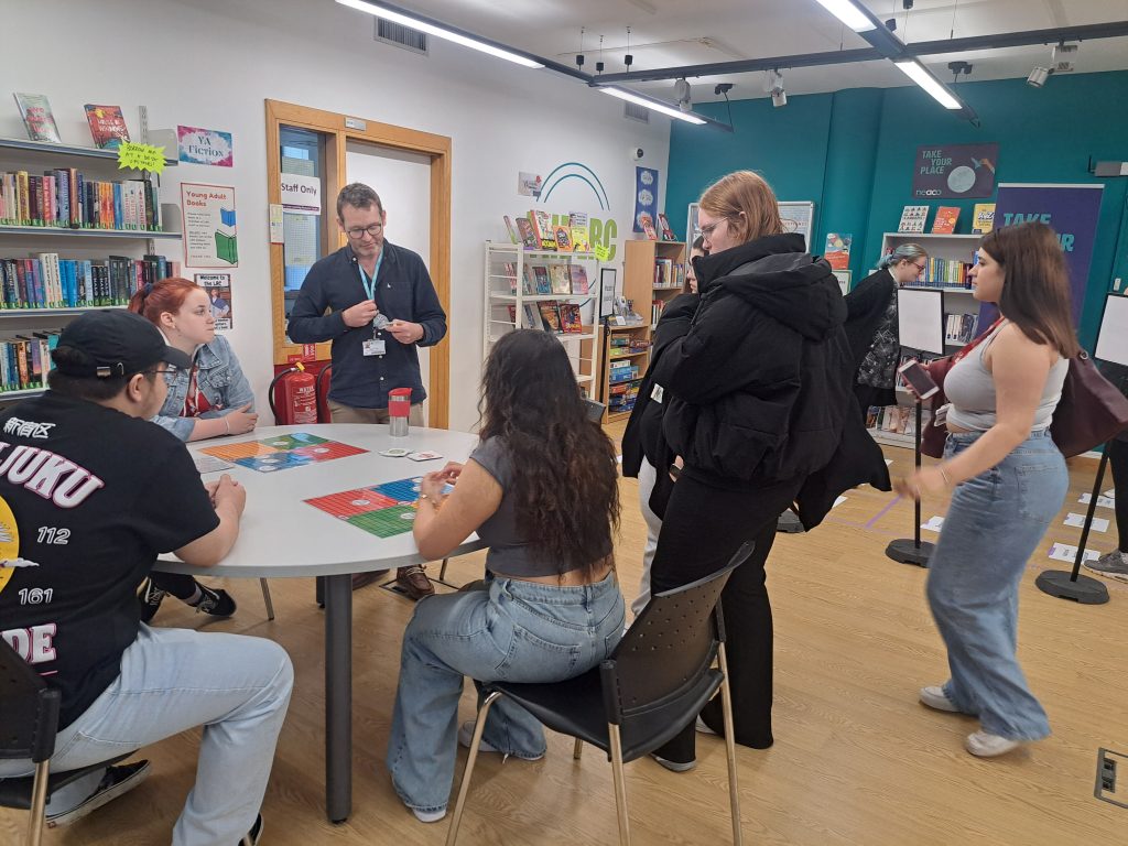 Students and staff play a tabletop board game